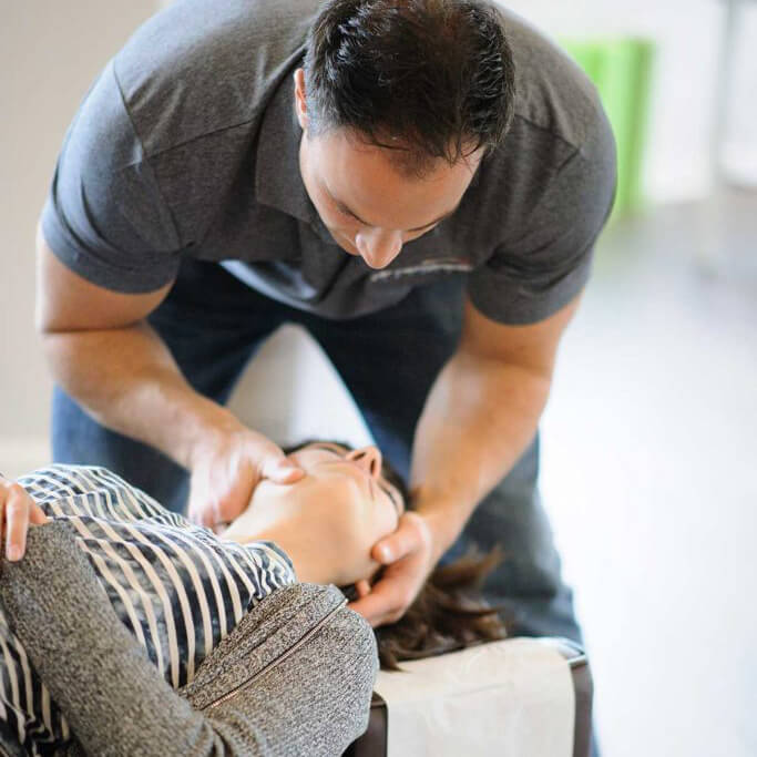 Dr. Marco Ferrucci, a chiropractor, providing neck adjustment to a patient