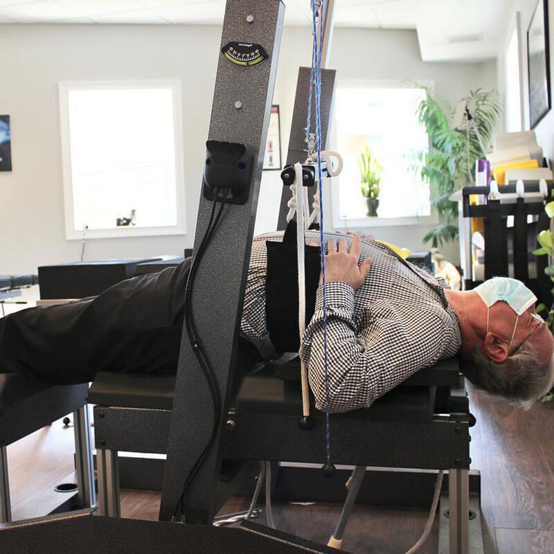 Patient undergoing treatment on a spinal traction device at 'The Chiropractic Source' clinic