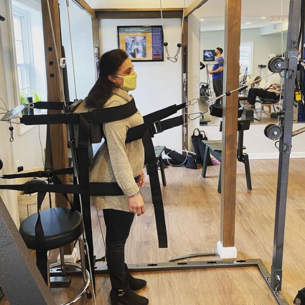 Patient undergoes spinal alignment therapy with specialized equipment at 'The Chiropractic Source' clinic.