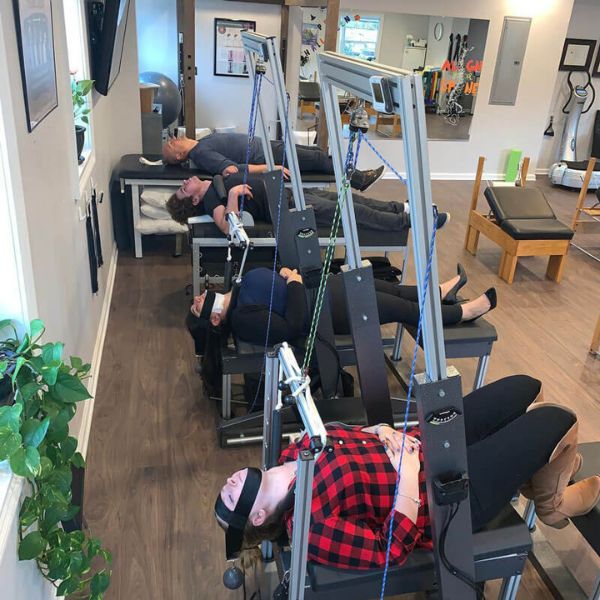 Patients receiving treatment at 'The Chiropractic Source' with various spinal care equipment in use.
